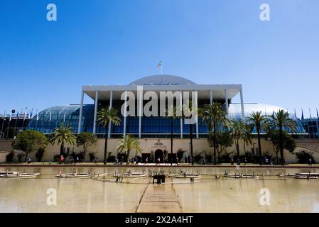 Symphonie ensoleillée d'architecture et de nature : le Palau de la Música Valenciana se dresse haut, sa façade blanche brillante sous le ciel Azur Banque D'Images