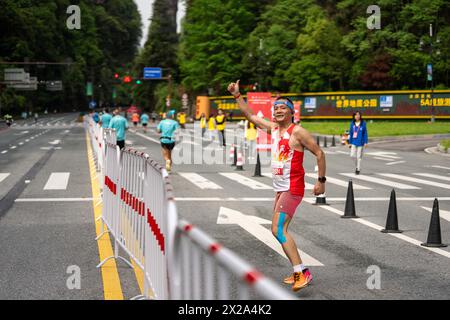 Zhangjiajie, province chinoise du Hunan. 21 avril 2024. Un participant fait un geste devant la caméra lors du marathon de Zhangjiajie Wulingyuan 2024 qui s'est tenu au parc forestier national de Zhangjiajie à Zhangjiajie, dans la province du Hunan, au centre de la Chine, le 21 avril 2024. POUR ALLER AVEC LES coureurs kenyans remporter le marathon de Wulingyuan dans le 'Avatar World' de Chine crédit : Chen Sihan/Xinhua/Alamy Live News Banque D'Images