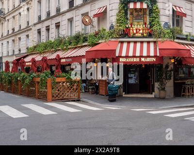 Paris, France, 19 avril 2024 : les touristes visitent le restaurant paris brasserie martin en rouge et décoration florale, vélos debout dans la rue, p Banque D'Images