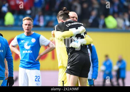 Rostock, Allemagne. 21 avril 2024. Football : Bundesliga 2, Hansa Rostock - 1. FC Magdeburg, Journée 30, Ostseestadion. Le gardien de Magdebourg Dominik Reimann embrasse Baris Atik (avant) après la victoire 0:2. Crédit : Gregor Fischer/dpa - REMARQUE IMPORTANTE : conformément aux règlements de la DFL German Football League et de la DFB German Football Association, il est interdit d'utiliser ou de faire utiliser des photographies prises dans le stade et/ou du match sous forme d'images séquentielles et/ou de séries de photos de type vidéo./dpa/Alamy Live News Banque D'Images