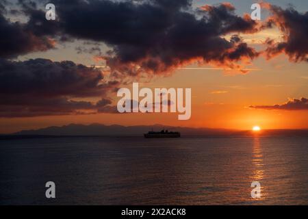 Grand angle d'un voyage en bateau de croisière contre des nuages calmes dramatiques pendant le lever du soleil à zante, Zakynthos, Grèce Banque D'Images