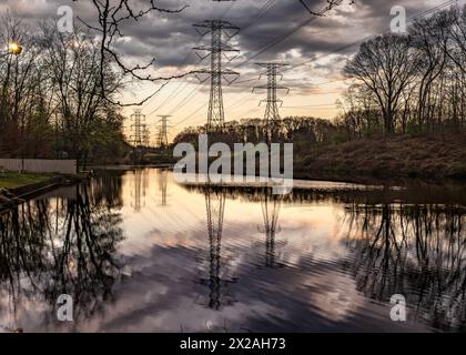 Mahwah, NJ - US- avril 14, 2024 vue horizontale grand angle des reflets sur le coucher du soleil dans l'étang serein Winter's Pond dans Mahwah's Winter's Park. Banque D'Images