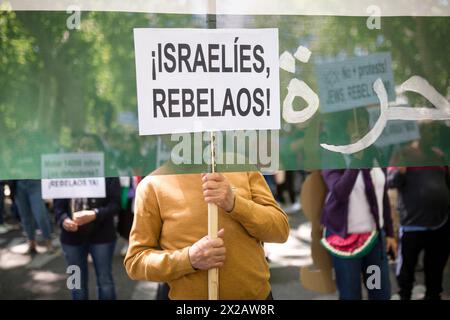 Madrid, Espagne. 21 avril 2024. Un manifestant tient une pancarte qui lit en espagnol "Israelies rebelaos", lors d'une manifestation de solidarité avec le peuple palestinien. Les manifestants défilent dans les rues principales de Madrid, sous le slogan "arrêtons le génocide en Palestine", exigeant que le gouvernement espagnol arrête le commerce d'armes avec Israël. Crédit : SOPA images Limited/Alamy Live News Banque D'Images