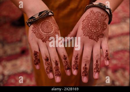 New Delhi, Inde. 21 avril 2024. Une femme indienne montre ses mains peintes avec du mehandi, une forme de décoration temporaire de la peau utilisant une pâte créée avec du henné, lors de la cérémonie Haldi avant le mariage. (Crédit image : © Deep Nair/ZUMA Press Wire) USAGE ÉDITORIAL SEULEMENT! Non destiné à UN USAGE commercial ! Banque D'Images