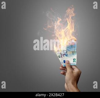 Main tenant des billets en euros brûlés Banque D'Images