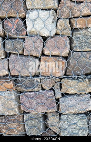 Texture d'un mur de gabion, cages remplies de roches. Banque D'Images