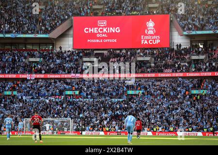 Les fans de Coventry City attendent un VAR check pour le quatrième but de leur équipe du match avant qu'il ne soit exclu pour hors-jeu lors de la demi-finale de la Coupe de football Emirates FA au stade de Wembley, à Londres. Date de la photo : dimanche 21 avril 2024. Banque D'Images