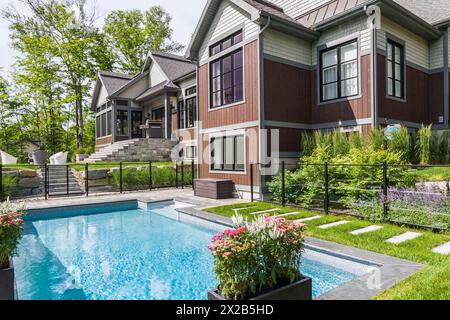 En piscine et vue arrière de la pierre naturelle et de bois teint brun et bardeaux de cèdre revêtu de style bungalow de luxe home dans su Banque D'Images