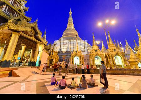 Shwedagon Pagoda, Yangon, Myanmar, Asie, Groupe de personnes dans la soirée devant l'impressionnante Pagode Shwedagon Banque D'Images