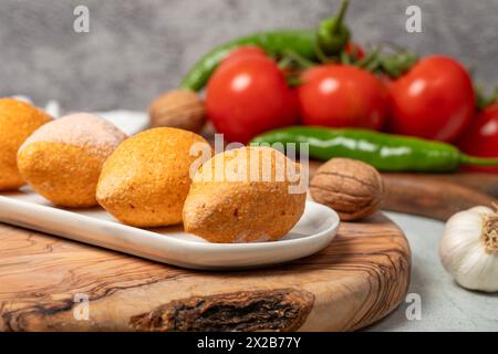 Boulettes de viande farcies congelées non cuites. Kibbeh ou kibbeh sur une planche de service en bois. Gros plan Banque D'Images