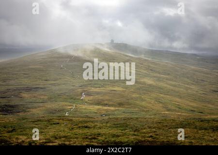 La Pennine Way traversant Great Dun est tombée dans les Pennines du Nord, avec le radôme de contrôle de la circulation aérienne visible dans la brume Banque D'Images