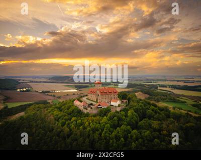 Luftbild Die Veste Wachsenburg, häufig auch nur kurz Wachsenburg genannt, ist eine zu den Drei Gleichen gehörende mittelalterliche Gipfelburg. IM Laufe ihrer Geschichte wechselte die Burg häufig ihren Besitzer, wurde zerstört und häufig um- und ausgebaut : besonders 1900 bis 1913 zur Aufnahme der umfangreichen Wachsenburg-Sammlungen zur Heimat- und Heeresgeschichte. Letztere Ging 1946 verloren, das Heimatmuseum musste 1962 schließen. Heute dient die Wachsenburg, wie schon lange, als Ausflugsgaststätte, seit 1966 als Hotel, und sie beherbergt ein kleines, privat geführtes Museum. Wachsenburg Thü Banque D'Images