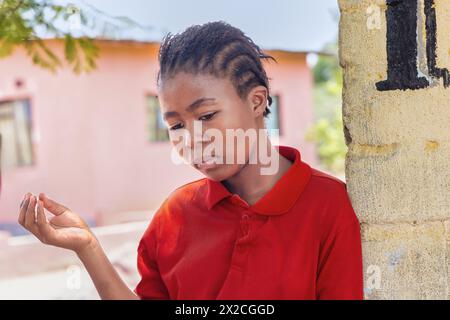 adolescente africaine avec des tresses devant la maison dans le township pauvre, établissement informel Banque D'Images