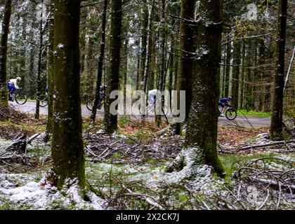 Liège, Belgique, 21 avril 2024,coureurs vus à travers des arbres couverts de neige pendant Liège Bastonge Liège, Belgique, 21 avril 2024, Credit:Chris Wallis/Alamy Live News Banque D'Images