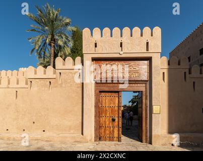 Rustaq, Oman - 14 février 2023 : porte d'entrée avec palmier au château et fort Al Hazm qui date de 1708 dans la péninsule arabe. Banque D'Images