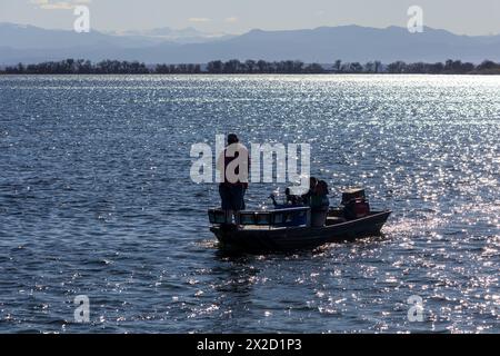 Denver, Colorado - 14 avril 2024 : trois pêcheurs sur un bateau dans le parc d'État de Barr Lake, Colorado Banque D'Images