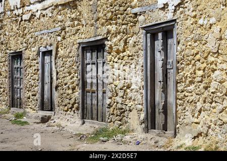 Quatre portes en bois dans un vieux bâtiment en pierre dans une ville côtière en Tanzanie Banque D'Images