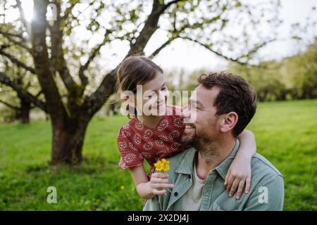 Père regardant sa fille avec amour dans la nature printanière. Concept de fête des pères. Banque D'Images