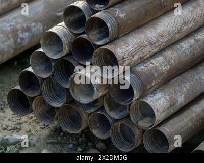 pile de tuyaux forés sur le sol. tuyaux métalliques rouillés de perçage usagés Banque D'Images