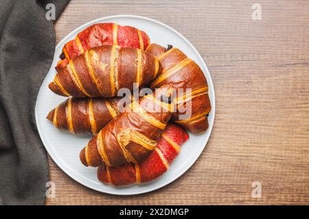 Croissants fruités et chocolat fraîchement cuits sur une assiette sur une table de cuisine. Vue de dessus. Banque D'Images