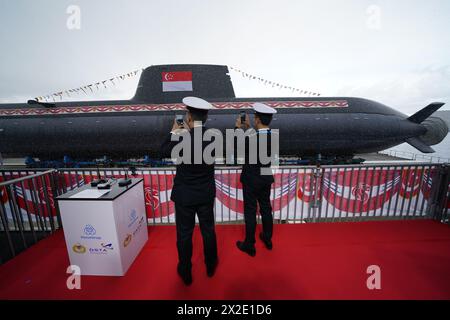 Kiel, Allemagne. 22 avril 2024. Des membres de la Marine singapourienne photographient un sous-marin de type 218SG au chantier naval Howaldtswerke-Deutsche Werft AG. Ce sous-marin est le dernier des quatre sous-marins de type 218SG construits par ThyssenKrupp Marine Systems pour la République de Singapour. Crédit : Marcus Brandt/dpa/Alamy Live News Banque D'Images