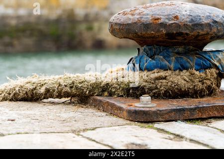 Cordes marines attachées sur une planche d'amarrage de sureau et rouillé sur le port du port. Banque D'Images