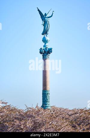 Statue angélique pour les morts à la guerre saluant haut sur une colonne au-dessus des fleurs de cerisier rose fleuries commémore la mort de l'amiral Ivar Huitfeldt Banque D'Images