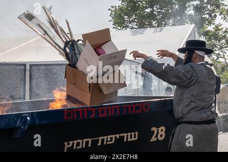 Jérusalem, Israël. 22 avril 2024. Les juifs ultra orthodoxes brûlent des morceaux de pain, des produits levés et des articles faits de levure dans le chametz biur cérémoniel, brûlent du pain levé, destiné à nettoyer le pays pendant la Pâque, qui commence cet après-midi au coucher du soleil. Crédit : NIR Alon/Alamy Live News Banque D'Images