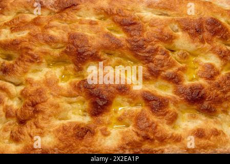 Focaccia avec de l'huile d'olive en plein cadre comme texture de fond, texture de croûte dorée de pain plat - motif Banque D'Images