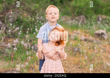 Jeune frère et soeur câlin dans le champ de fleurs Banque D'Images