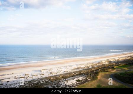 Scène de plage sereine avec sable expansif et vagues tranquilles Banque D'Images