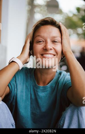 Heureuse femme riante tirant sa casquette sur ses yeux. Idiot. Banque D'Images