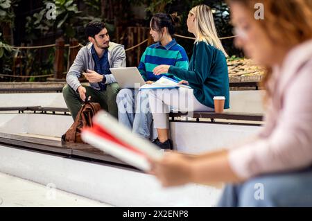 Groupe diversifié d'étudiants se trouvant dans l'apprentissage du campus ensemble. Banque D'Images