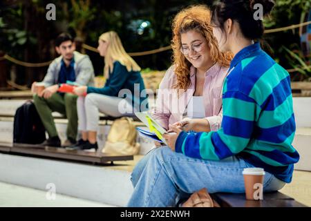 Groupe diversifié d'étudiants se trouvant dans l'apprentissage du campus ensemble. Banque D'Images