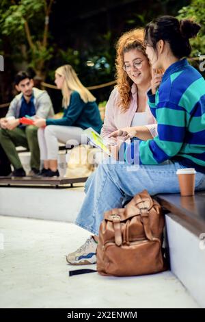 Groupe diversifié d'étudiants se trouvant dans l'apprentissage du campus ensemble. Banque D'Images