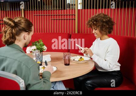 couple d'horizons divers s'engagent dans une conversation profonde à une table de café confortable, entouré par une ambiance paisible. Banque D'Images