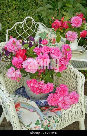 Botanique, nature morte de roses roses roses et rouges dans une cruche en porcelaine sur une chaise en osier à l'extérieur, SUPPLÉMENT-DROITS-AUTORISATION-INFO-NON-DISPONIBLE Banque D'Images