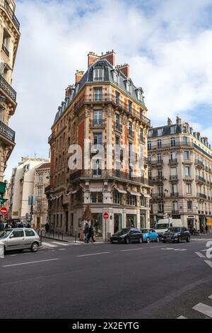 Coin parisien historique avec des bâtiments haussmanniens et une vie de rue animée. Banque D'Images