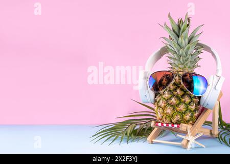 Vacances d'été créatives, fête et fond de vacances avec ananas dans des lunettes de soleil et des écouteurs, musique d'été, concept d'ambiance de loisirs Banque D'Images