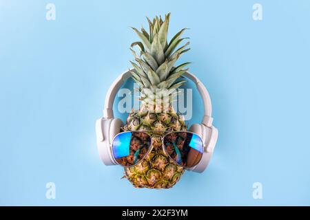 Vacances d'été créatives, fête et fond de vacances avec ananas dans des lunettes de soleil et des écouteurs, musique d'été, concept d'ambiance de loisirs Banque D'Images