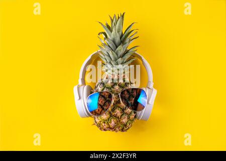 Vacances d'été créatives, fête et fond de vacances avec ananas dans des lunettes de soleil et des écouteurs, musique d'été, concept d'ambiance de loisirs Banque D'Images