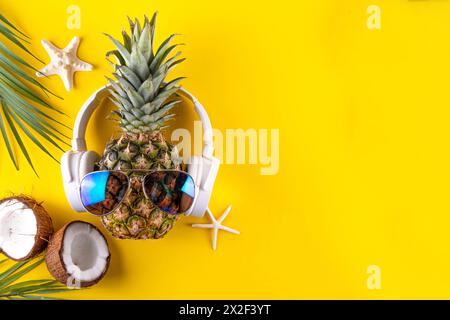 Vacances d'été créatives, fête et fond de vacances avec ananas dans des lunettes de soleil et des écouteurs, musique d'été, concept d'ambiance de loisirs Banque D'Images