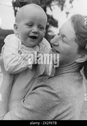 Un VILLAGE SAUVE : ÉPARGNE NATIONALE À LEWKNOR, OXFORDSHIRE, ANGLETERRE, 1941 - Un portrait d'un John Andrew souriant, âgé de 6 mois, avec sa mère. John vaut son poids en or, car il pèse 18 lb et a 18 £ en certificats d'épargne nationaux Banque D'Images