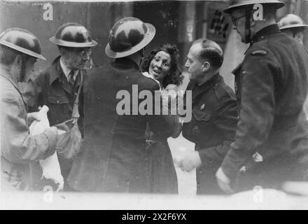 Photographie en noir et blanc de 1944 montrant les dégâts causés par les bombes et les victimes causées par les bombardements de guerre. L'image documente la destruction des bâtiments et l'impact humain des attaques aériennes pendant la seconde Guerre mondiale Banque D'Images