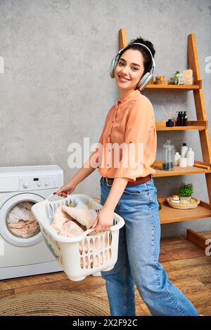 Une femme élégante tenant un panier de poulets tout en se tenant devant une machine à laver à la maison. Banque D'Images