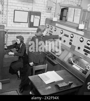 LA RECONSTRUCTION d'« UN INCIDENT » : FORMATION À LA DÉFENSE CIVILE À FULHAM, LONDRES, 1942 - dans la salle de contrôle des pompiers, un appel est reçu par des travailleuses de la défense civile déclarant que les pompiers devraient assister à un incendie qui a éclaté sur les lieux de l'incident. Une lumière, indiquant un incendie, peut être vue, brille sur la gauche du panneau visuel Banque D'Images