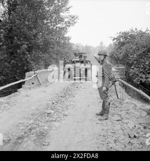 Un policier militaire britannique dirige une voiture de repérage Humber sur un pont au-dessus de la rivière Odon en Normandie le 16 juillet 1944. Banque D'Images