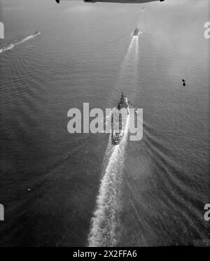 L'AUGUSTA ET SON ESCORTE DANS LA MANCHE. 14 JUILLET 1945, PHOTOGRAPHIE AÉRIENNE, APPROCHE DES DESCENTES. LE CROISEUR AMÉRICAIN AUGUSTA, TRANSPORTANT LE PRÉSIDENT TRUMAN À LA GRANDE RÉUNION DES TROIS, S'EST APPROCHÉ DES DOWNS AVEC SON ESCORTE DU CROISEUR BRITANNIQUE HMS BIRMINGHAM ET DES DESTROYERS HM SERAPIS, OBDURÉ, OBÉISSANT, ZÉLÉ, ZEPHYR, ET LE ZODIAC, ET LE CROISEUR AMÉRICAIN PHILADELPHIA. - L'AUGUSTA (premier plan) suivant dans le sillage de la PHILADELPHIE United States Navy, AUGUSTA (USS), croiseur lourd (1930) Banque D'Images