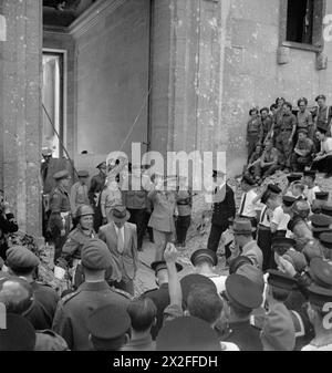Le premier ministre Winston Churchill quitte les ruines de la chancellerie d'Adolf Hitler à Berlin, en Allemagne, le 16 juillet 1945, après la fin de la seconde Guerre mondiale en Europe. Banque D'Images