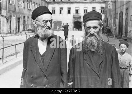 Deux hommes juifs âgés se tiennent debout dans la cour d'un immeuble du ghetto de Varsovie pendant la période de l'occupation nazie, d'octobre 1940 à mai 1943. Banque D'Images